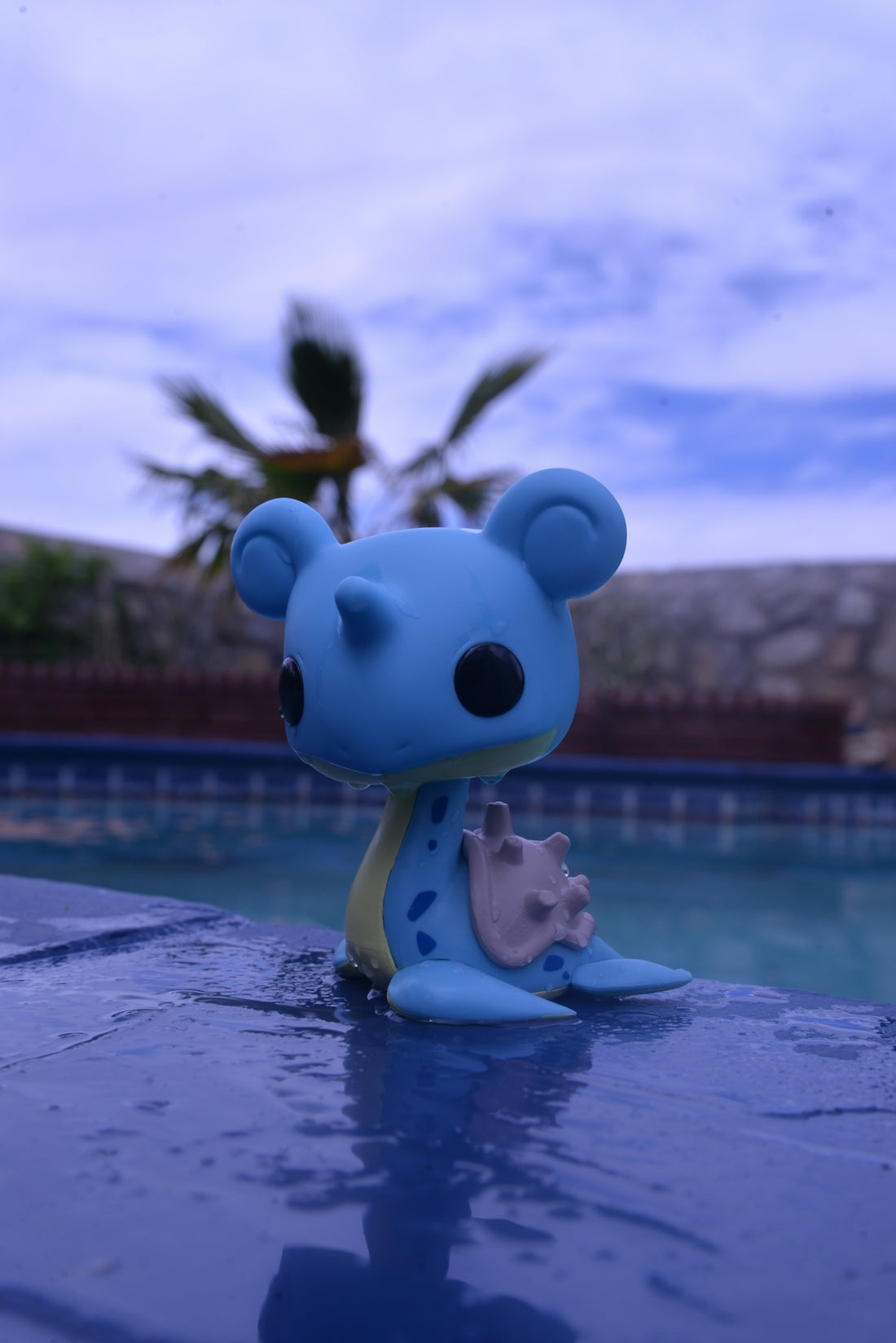 a blue bear figurine sitting on top of a pool