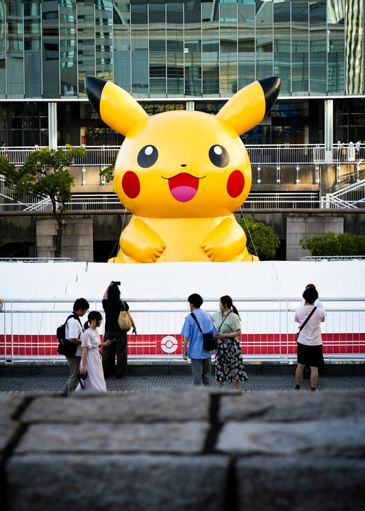 A group of people standing in front of a giant pikachu